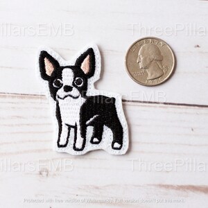 May include: An embroidered iron-on patch of a black and white Boston Terrier dog. The patch is about the size of a US quarter.