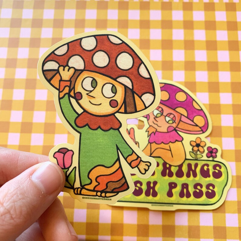 May include: Two cartoon mushroom characters with smiling faces. The mushroom on the left is wearing a green and orange outfit and has red and white spots on its cap. The mushroom on the right is wearing a pink and yellow outfit and has purple spots on its cap. The text "Shroom Kings Sh Pass" is written in a retro font on a yellow background.