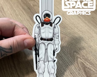 Könnte beinhalten: Weißer Vinyl-Aufkleber mit einem Cartoon-Soldaten, der einen weißen Skianzug trägt, ein Gewehr hält und Skier auf dem Rücken trägt. Der Soldat hat einen roten Bart und trägt einen weißen Helm mit schwarzem Visier. Der Aufkleber trägt den Text "HEADSPACE GRAPHICS" oben.