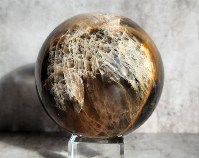 Black Moonstone sphere: Mysterious guide to inner depths. Promotes intuition, balance and spiritual growth for inner wisdom.