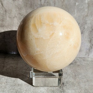 Boule de calcite ivoire : Énergie apaisante, favorise l'équilibre émotionnel et la clarté, subtilement chaleureuse avec un éclat doux et naturel.