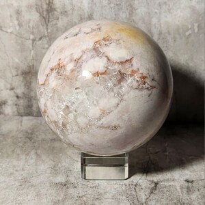 Sfera di agata floreale: motivi delicati, favoriscono la pace e la crescita spirituale. Pezzo decorativo unico per gli amanti dei cristalli e delle collezioni spirituali.