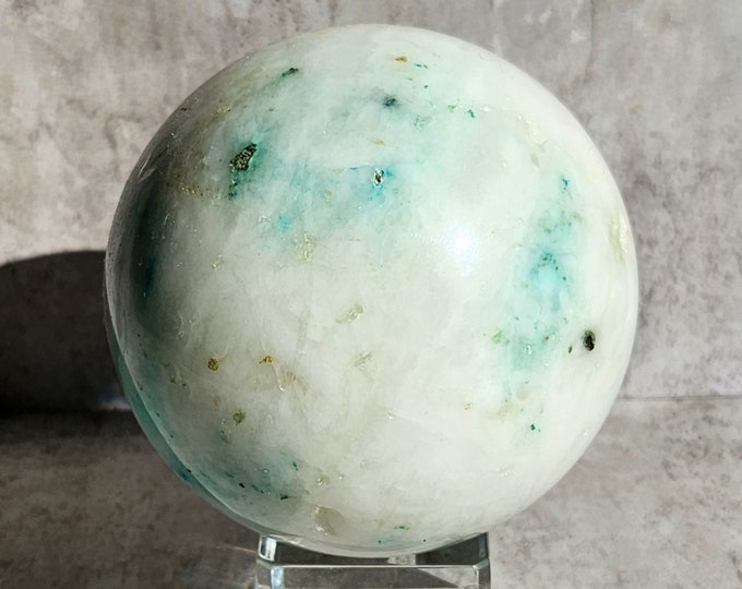 Amazonite sphere with white-grey matrix and turquoise accents. A clear, polished piece with a calm appearance and soft shine.