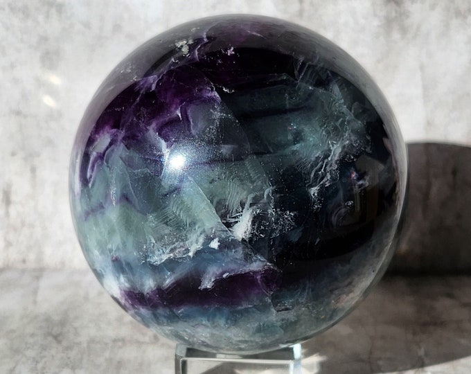 Rainbow fluorite sphere in purple and green: promotes focus, balance and intuition. Unique eye-catcher with calming energy.