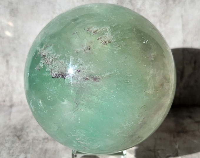 Pastel green fluorite sphere with almost translucent glow. Enhances clarity, inner peace and balance. Calm source that deepens focus.