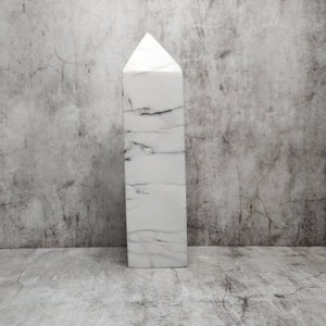 Howlite con venature calme e orizzontali. Favorisce la calma e la chiarezza mentale. Un oggetto potente e minimalista dall'aspetto naturale.