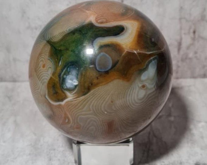 Ocean Jasper sphere: Wavy patterns and earthy tones. Promotes emotional balance, patience, healing and stimulates loving communication.
