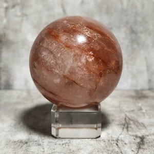 Sfera di Quarzo di Fuoco: Pietra potente che rafforza la passione e il coraggio, accende la creatività e dissipa le paure, incoraggiando l'azione