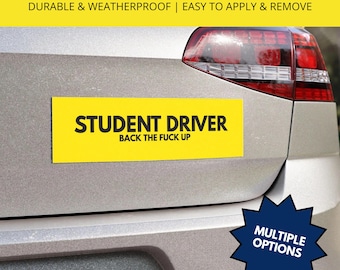 May include: A rectangular yellow car magnet featuring the black text STUDENT DRIVER on the top line and BACK THE FUCK UP on the bottom line. The magnet is displayed on the silver trunk of a vehicle with a red taillight visible in the upper right.