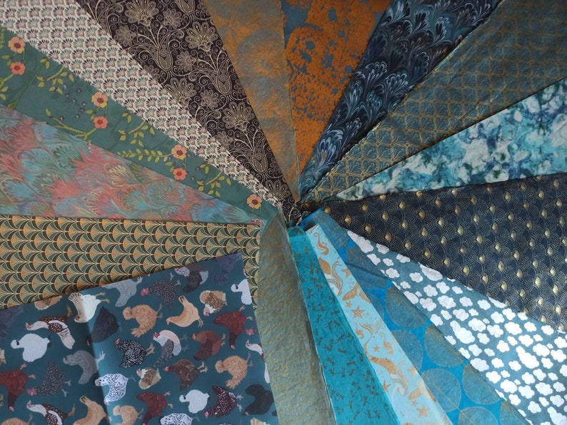 May include: A collection of 20 different patterned wrapping papers in shades of teal, blue, brown, and gold. The papers feature various designs, including geometric patterns, floral motifs, and animal prints.