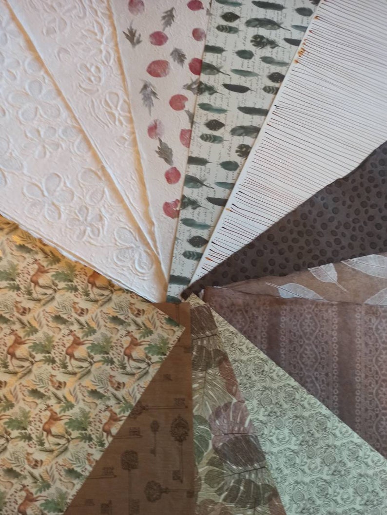 May include: A collection of patterned papers in various colors and designs, including floral, geometric, and animal prints. The papers are arranged in a fan shape, with the tips of the papers meeting in the center.