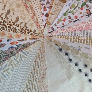 May include: A collection of patterned papers in various colors and designs, including floral, geometric, and abstract patterns. The papers are arranged in a fan shape, with the tips of the papers meeting in the center.