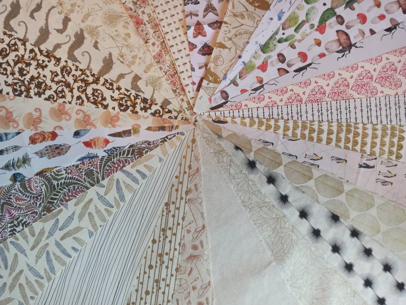 May include: A collection of patterned papers in various colors and designs, including floral, geometric, and abstract patterns. The papers are arranged in a fan shape, with the tips of the papers meeting in the center.