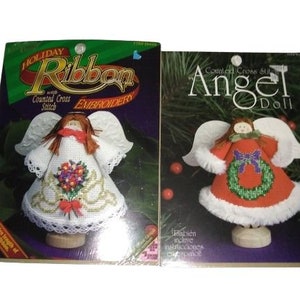 May include: Two craft kits for holiday ribbon embroidery and counted cross stitch angel dolls. The kits feature images of angel dolls with white wings and dresses, and include the text "Holiday Ribbon Embroidery" and "Angel Doll".