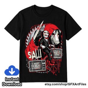 May include: A black short-sleeve t-shirt featuring a graphic print of the Saw movie character Billy the Puppet on a tricycle. The design includes a red hood, a saw blade, and two television screens displaying the text I WANT TO PLAY A GAME and LIVE OR DIE MAKE YOUR CHOICE.