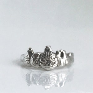 May include: A silver ring featuring a design of three mountains. The ring is made of metal and has a polished finish.