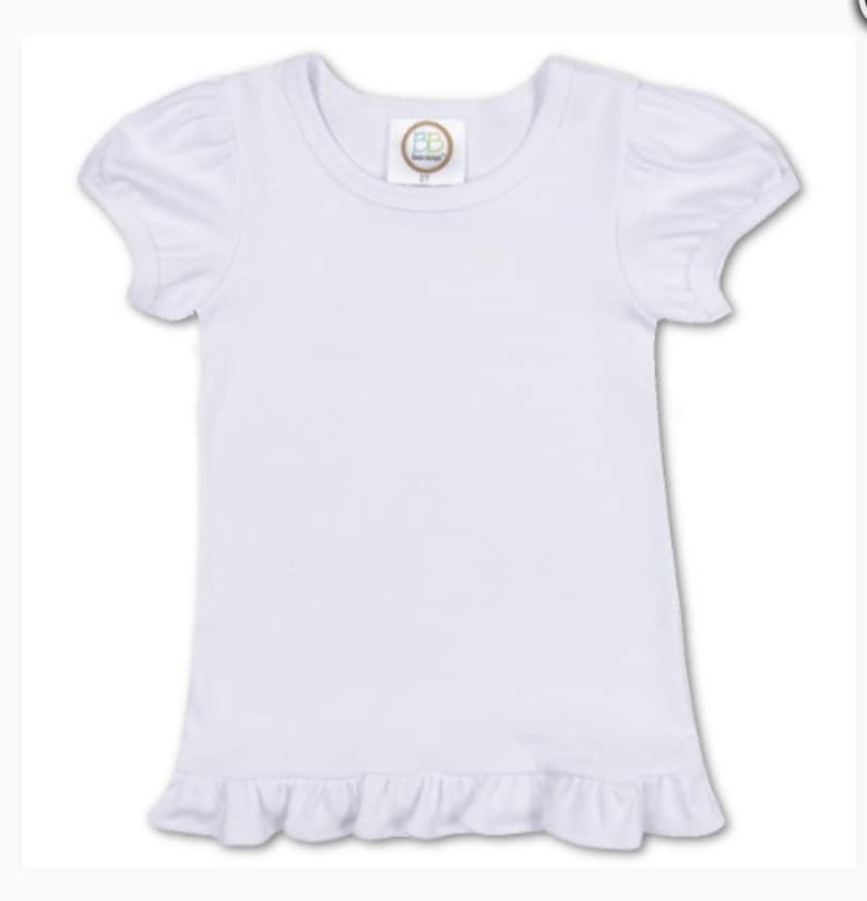 May include: White short-sleeved t-shirt with a ruffled hem. The shirt has a small tag with the letters "BB" on it.