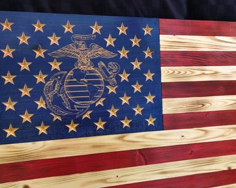 Puede incluir: Una bandera estadounidense de madera con un acabado desgastado. El campo azul presenta estrellas doradas y un emblema del Cuerpo de Marines tallado. Las rayas rojas y blancas también son de madera.