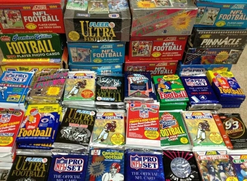 May include: A collection of various unopened packs of NFL football trading cards from the 1990s. The packs feature different brands, including Score, Fleer, Pinnacle, and Pro Set. Some packs have player photos, while others have team logos.