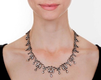 May include: A silver necklace with a delicate, cascading design set with small, sparkling diamonds.