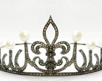 May include: A silver crown with a fleur-de-lis design and pearl accents.