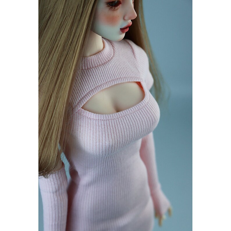 May include: A pink ribbed knit dress with a cutout at the chest. The dress has long sleeves and a fitted silhouette.