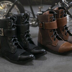 May include: Two pairs of black and brown lace-up boots with buckles. The boots have a rounded toe and a thick sole.