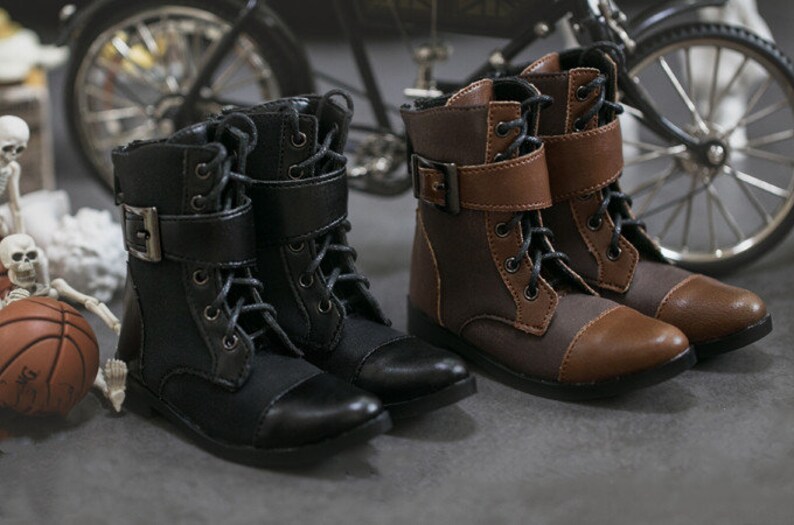 May include: Two pairs of black and brown lace-up boots with buckles. The boots have a rounded toe and a thick sole.