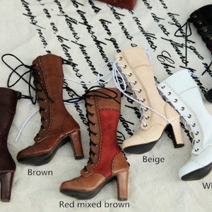 May include: A selection of high-heeled, lace-up boots in shades of dark brown, brown, red mixed brown, beige, white, and black. The boots feature a classic design with a pointed toe and a sturdy heel. The boots are displayed on a patterned fabric.