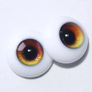 Peut inclure: Une paire d'yeux de poup&eacute;e r&eacute;alistes avec un iris brun et jaune et une pupille noire.