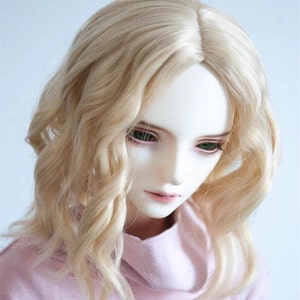 May include: A doll with long, wavy, light blonde hair. The doll is wearing a pink turtleneck sweater.