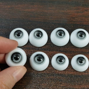 May include: Eight gray and white doll eyes with black pupils. The eyes are arranged in two rows of four.
