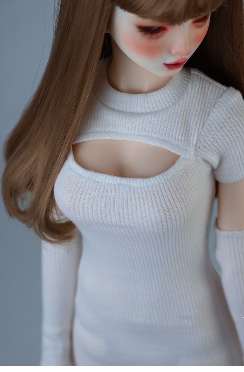 May include: White ribbed knit crop top with a cutout detail at the front. The top has short sleeves and a high neckline.
