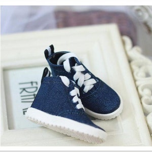 May include: A pair of blue denim high-top sneakers with white laces and white soles.