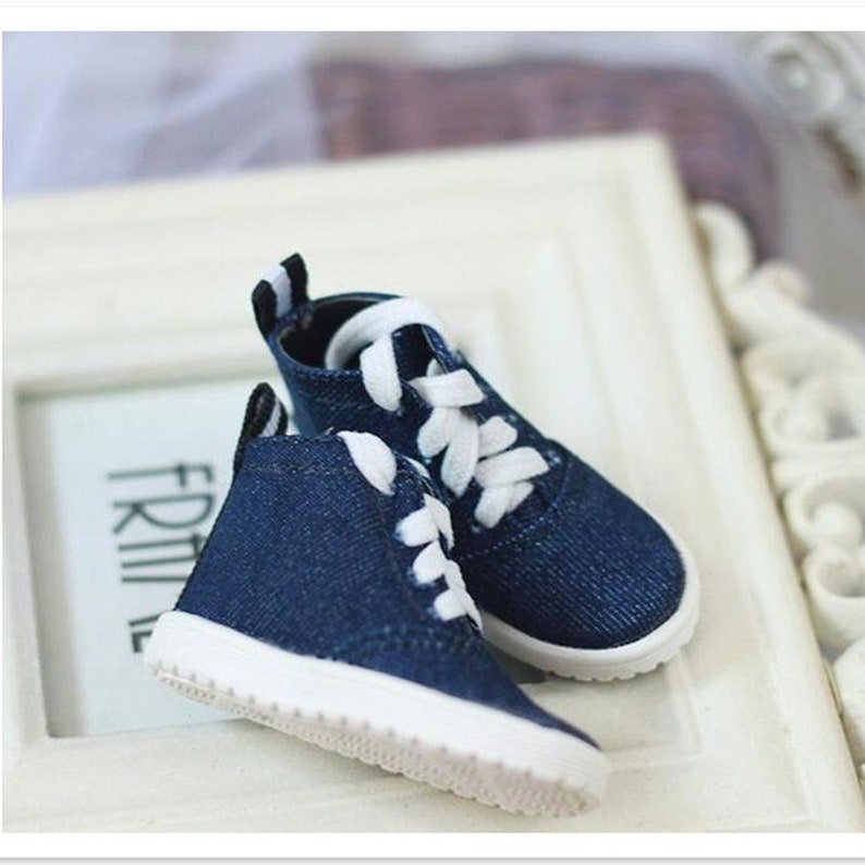May include: A pair of blue denim high-top sneakers with white laces and white soles.