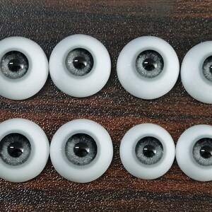 May include: Eight pairs of gray and black doll eyes with a glitter finish. The eyes are round and have a black pupil.