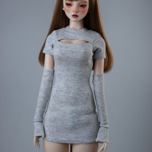 May include: A grey ribbed knit dress with a cutout neckline and matching long sleeves. The dress is fitted and has a short length.