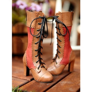 May include: Brown and red lace-up boots with a high heel. The boots have a mix of smooth and textured leather, with decorative stitching and scalloped edges. Black laces thread through brass eyelets.