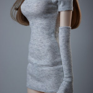 May include: A grey ribbed knit dress with a cutout at the neckline and matching ribbed knit arm warmers.