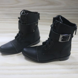 May include: A pair of black leather ankle boots with laces and a buckle. The boots have a pointed toe and a low heel.
