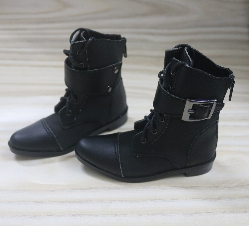 May include: A pair of black leather ankle boots with laces and a buckle. The boots have a pointed toe and a low heel.