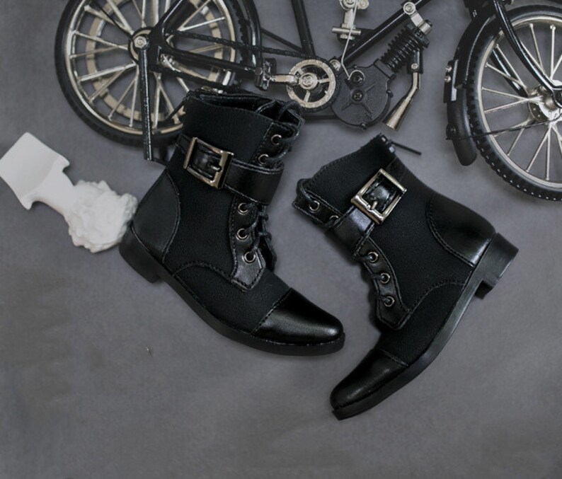 May include: A pair of black leather ankle boots with buckles and laces. The boots have a pointed toe and a low heel.