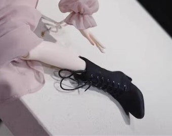 May include: Black lace-up ankle boots with a pointed toe. The boots are made of a soft, supple leather and have a comfortable fit.