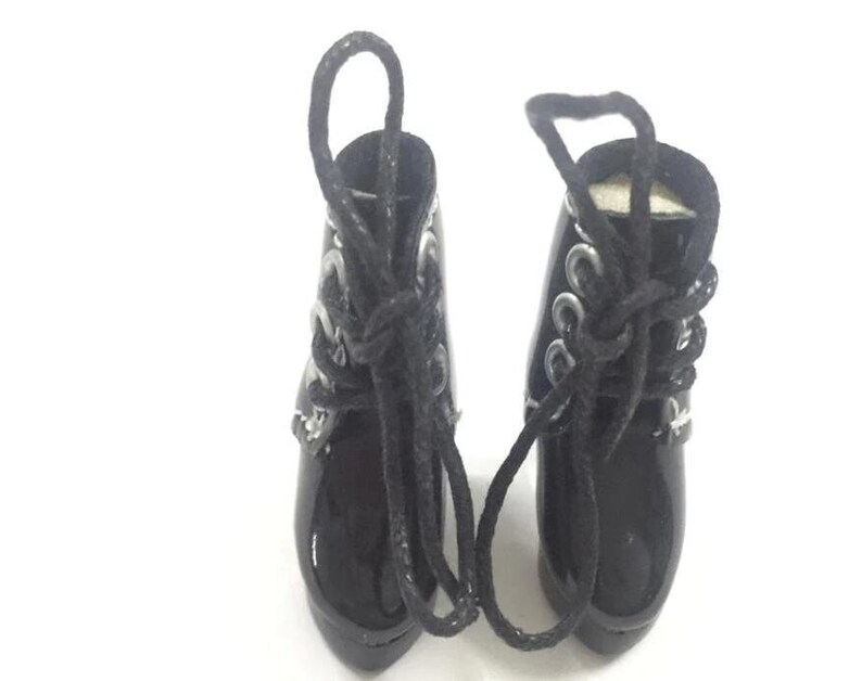 May include: A pair of black patent leather ankle boots with silver buckles and black laces. The boots have a pointed toe and a high heel.