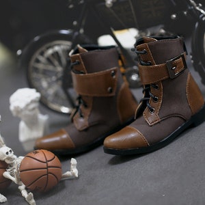 May include: A pair of brown and black leather ankle boots with buckles and laces. The boots have a rounded toe and a low heel.