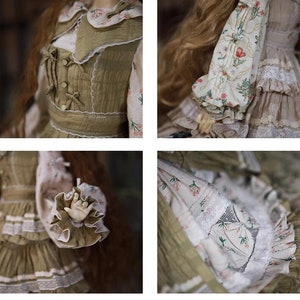 May include: A doll wearing a green and white dress with floral print and lace trim. The dress has a ruffled skirt and a fitted bodice with a lace collar. The doll has long brown hair.