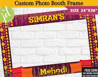 May include: A photo booth frame with a purple background and gold glitter. The frame is decorated with yellow, orange, and red Indian-inspired designs. The text "SIMRAN'S Mehndi" is at the top of the frame. The frame is 24 inches by 36 inches.