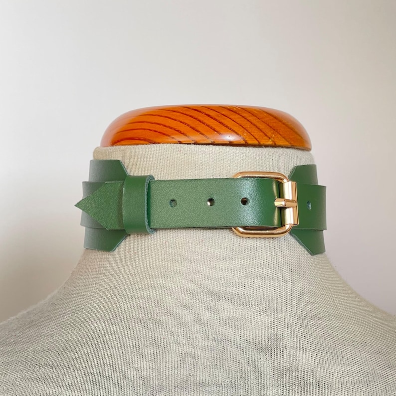 Close-up of a wide green leather collar with gold hardware.
Back view.