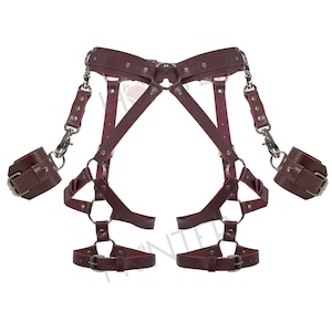 May include: A burgundy leather harness with straps and buckles, featuring two sets of wrist cuffs connected by chains.