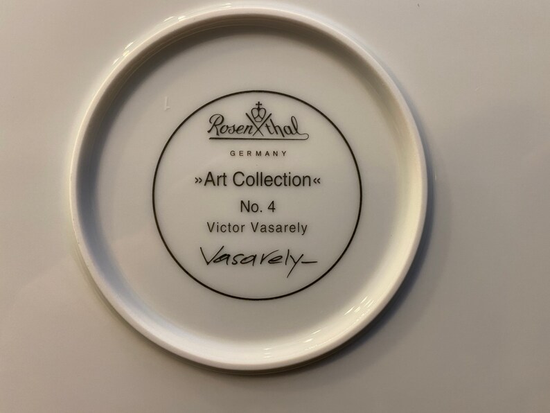Puede incluir: Un plato de cer&aacute;mica blanco con un logotipo en blanco y negro para Rosenthal Germany Art Collection No. 4 Victor Vasarely.